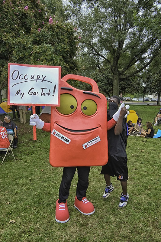 Protestors representing the Coalition to Occupy Wall Street South set up camp in Marshall Park in Charlotte, North Carolina during the Democratic National Convention, 2012. This protestor showed up in a creative costume with the sign "occupy my gas tank" and a label "can Obama."