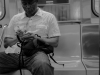 Man drawing as he rides the  A subway, Manhattan, New York.
