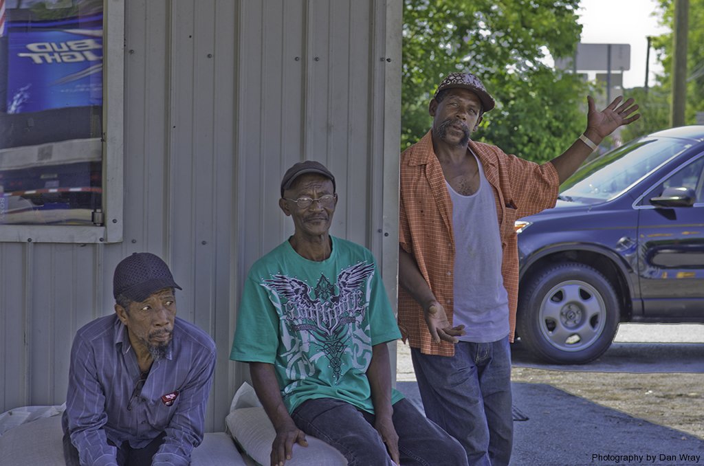 Three African American men hanging out at the corner gas station convenient store in Mount Gilead, North Carolina.