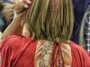 Young woman with multi-colored hair and upper back tatoo.