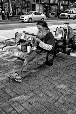 Grey bearded man on bench, uptown Charlotte, North Carolina.